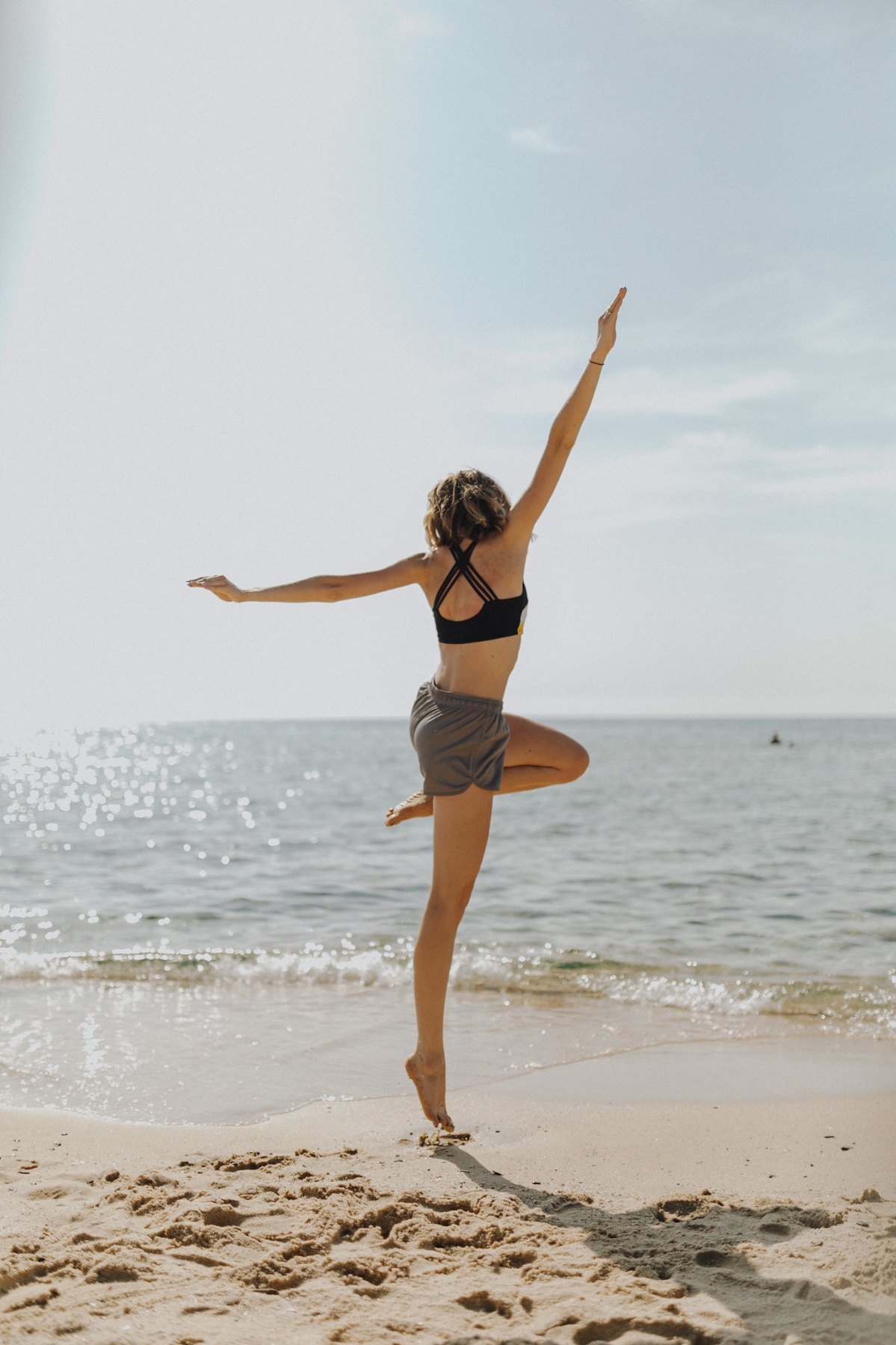 Woman balancing on a beach near the ocean